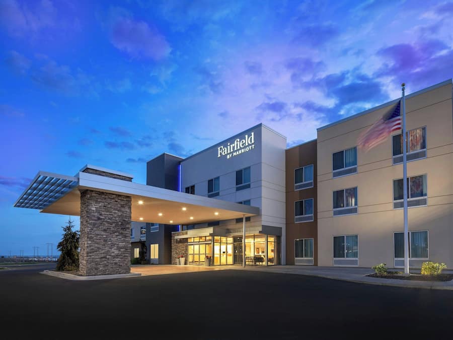 Et Fairfield by Marriott hotel med et moderne design, inklusive en overdækket indgang og et amerikansk flag.