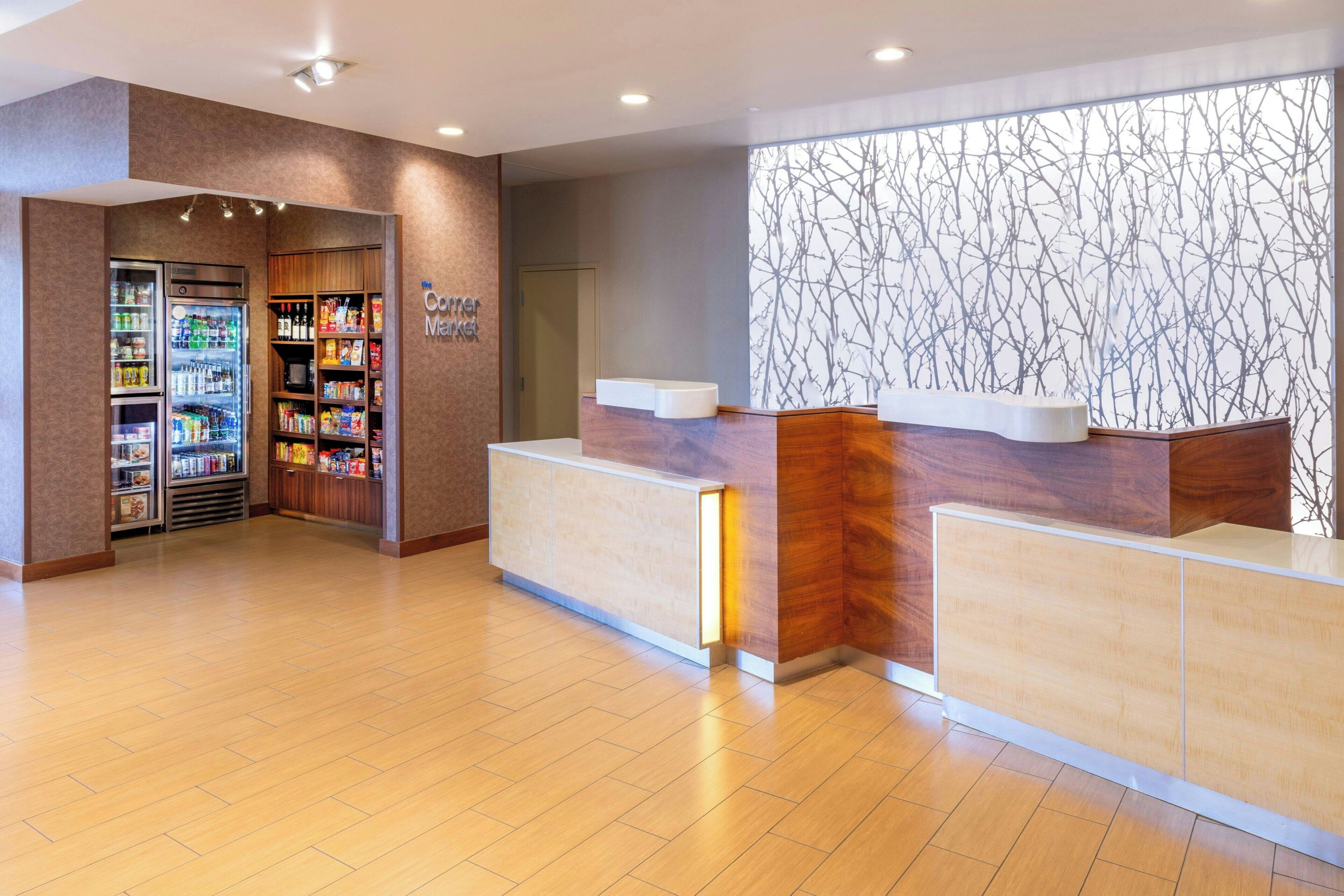 A reception area with a counter, a vending machine, and a wall with a tree pattern.