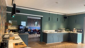 Uma cozinha moderna com ilha central, piso de madeira e vista para uma sala de jantar.