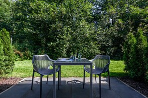 Una mesa con dos sillas en un jardín.