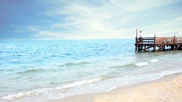 Een privéstrand, parasols, strandlakens