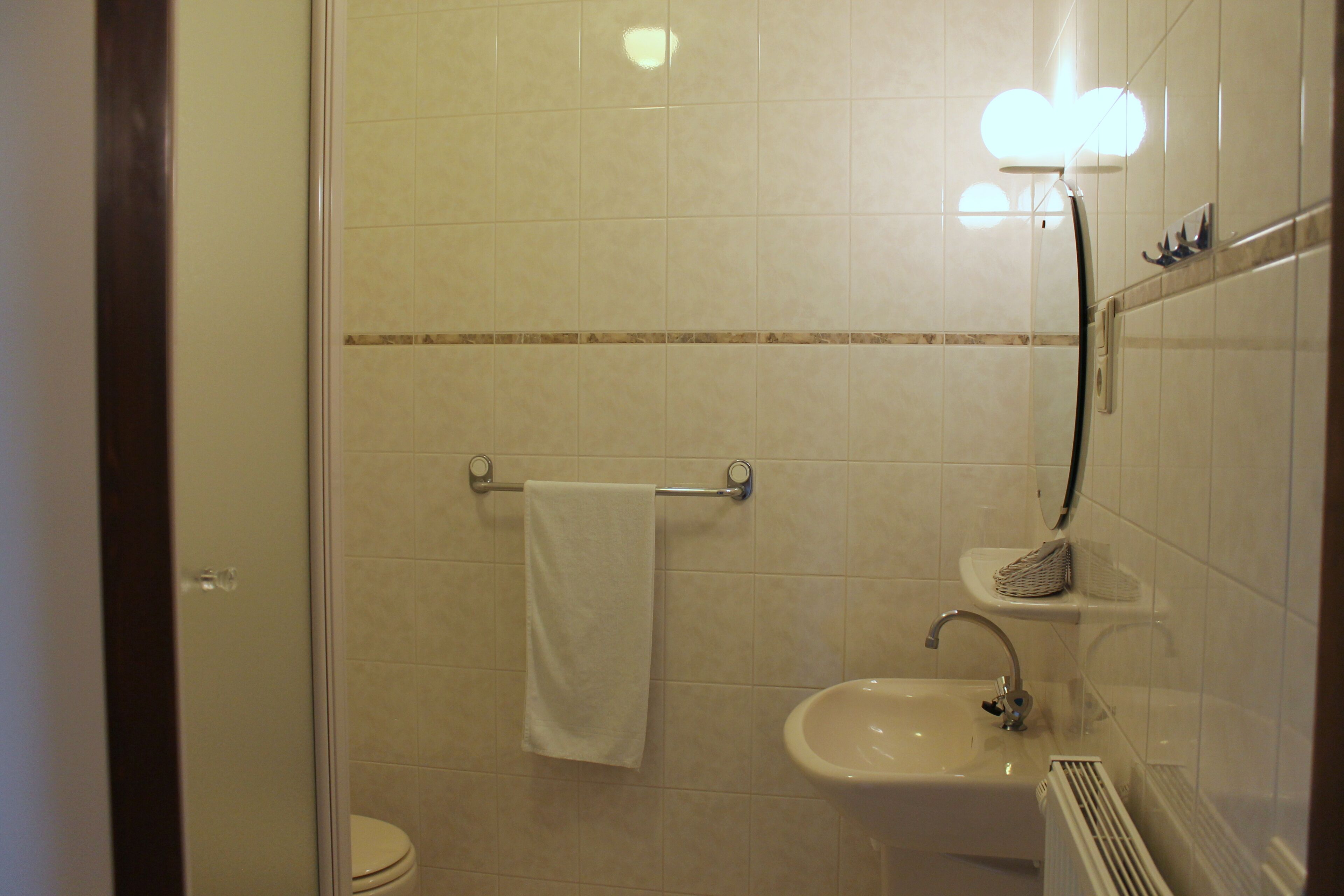 A bathroom with a toilet, sink, and towel rack.