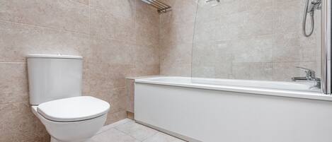 Un baño moderno con inodoro, ducha y bañera.