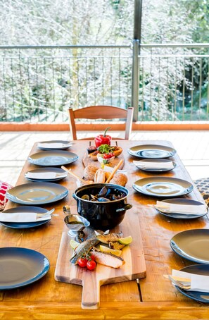 A dining table set with plates, bowls, and a wooden board with food items. - Woodenbridge Hotel (Arklow)
