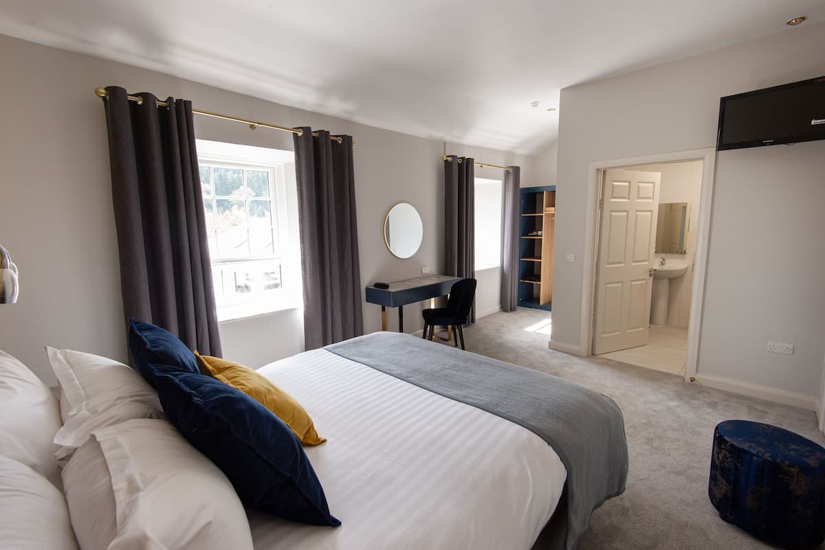 A bedroom with a bed, a desk, and a walk-in closet.