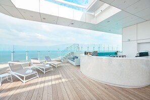 A modern outdoor lounge area with a bar, seating, and a view of the ocean. - Radisson Blu Resort, Swinoujscie (Swinoujscie)