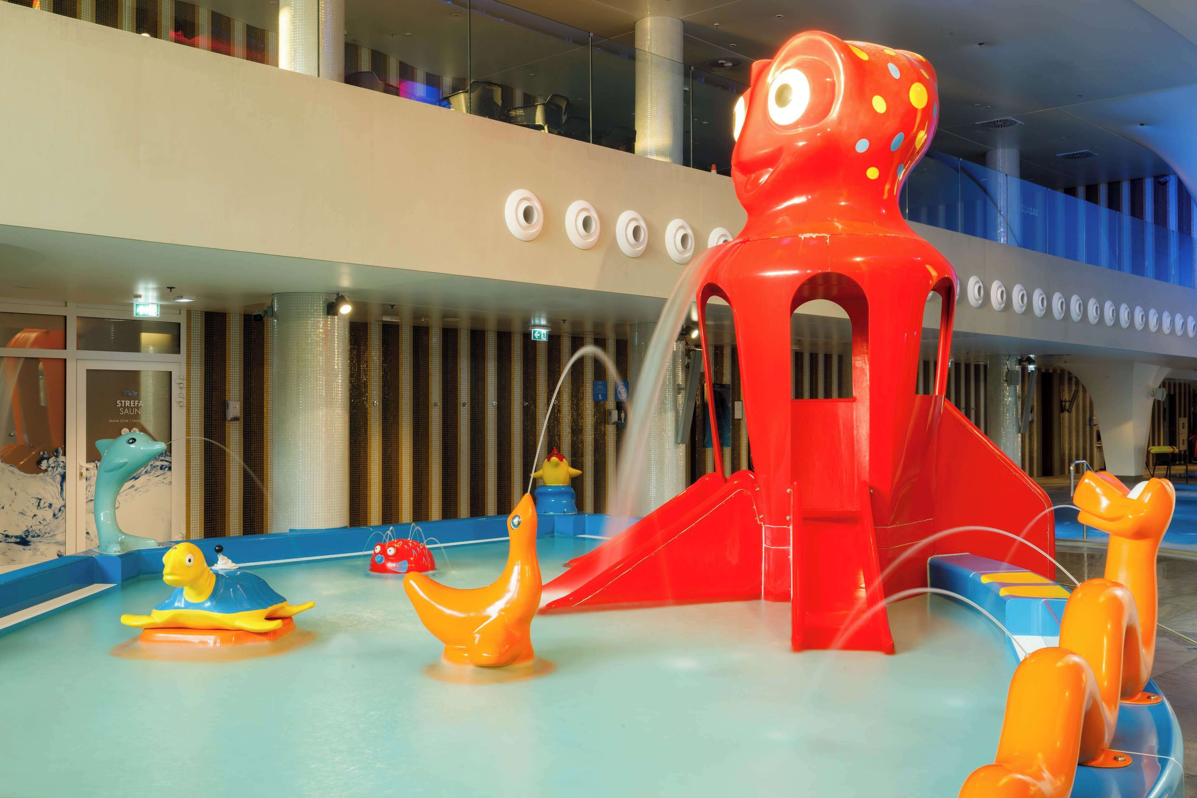 Un espace de jeux pour enfants avec différents toboggans aquatiques colorés et des structures de jeu.