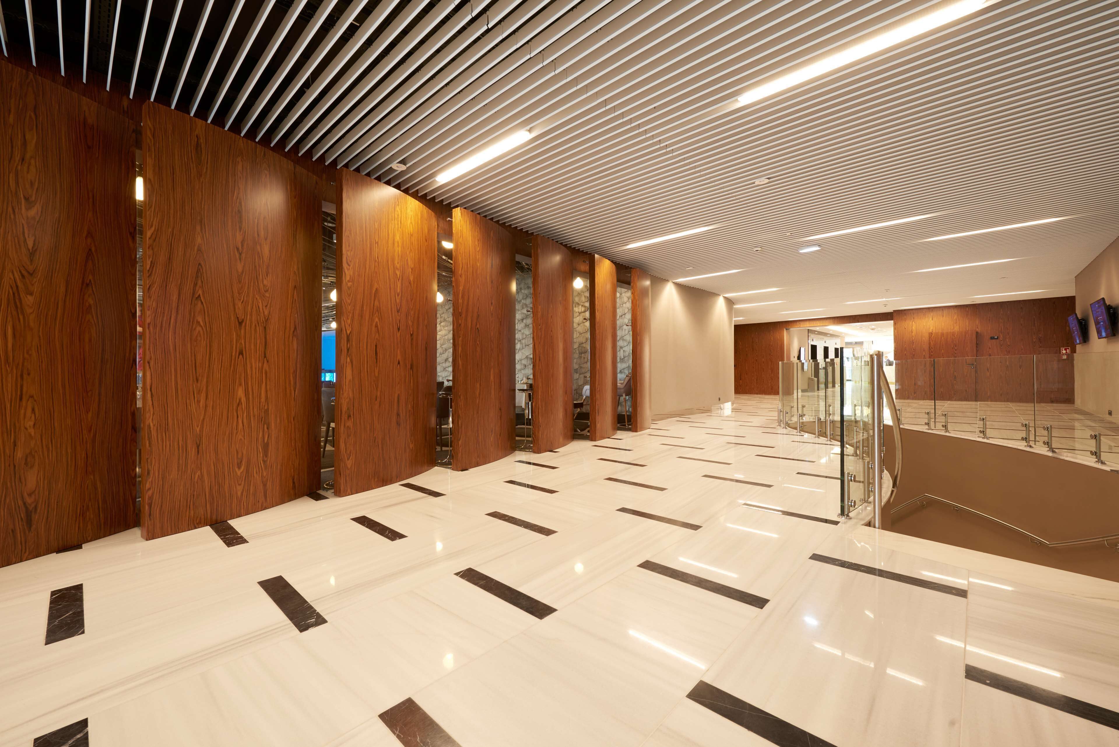 A spacious hallway with wooden paneling and a polished marble floor.