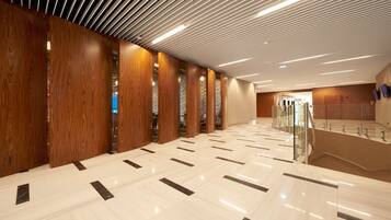 A spacious hallway with wooden paneling and a polished marble floor.