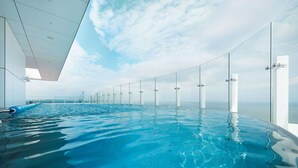 Ein Innenpool mit Wasserspiegel, Glaswänden und Blick zum Himmel.