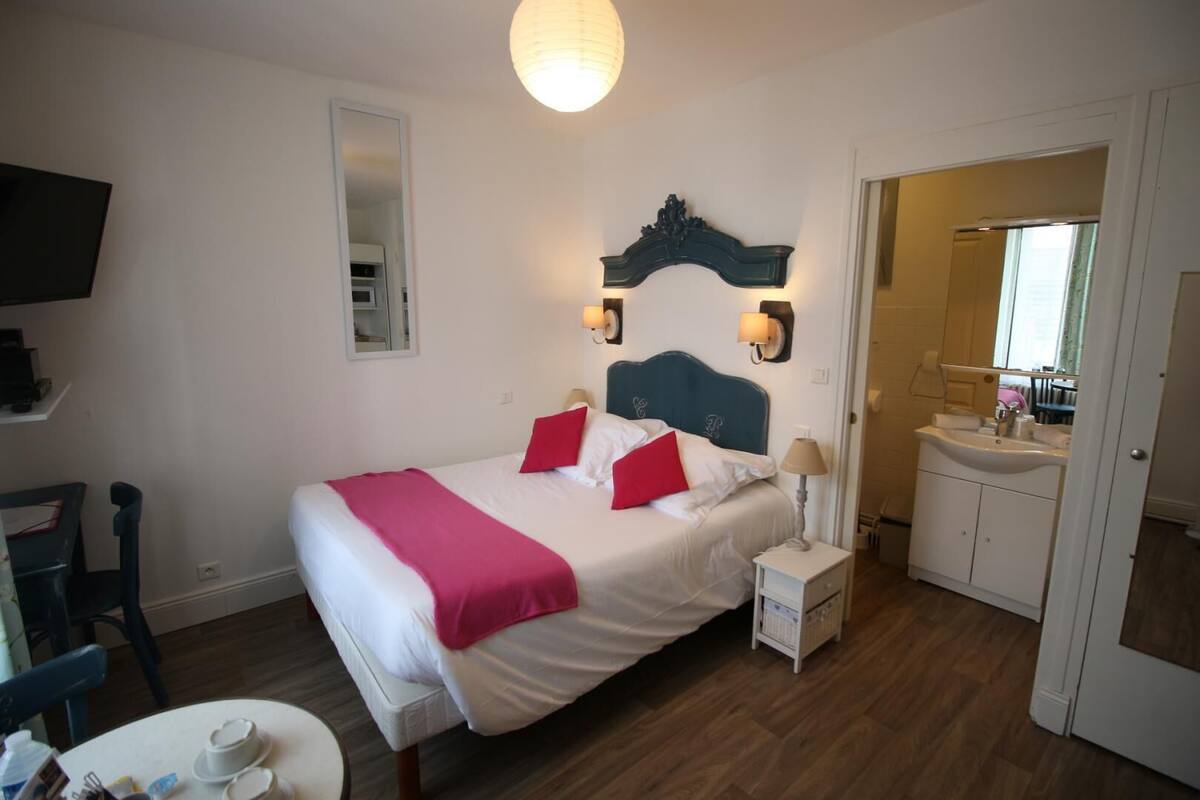 A neatly arranged bedroom with a bed, bedside table, and a small bedside lamp.