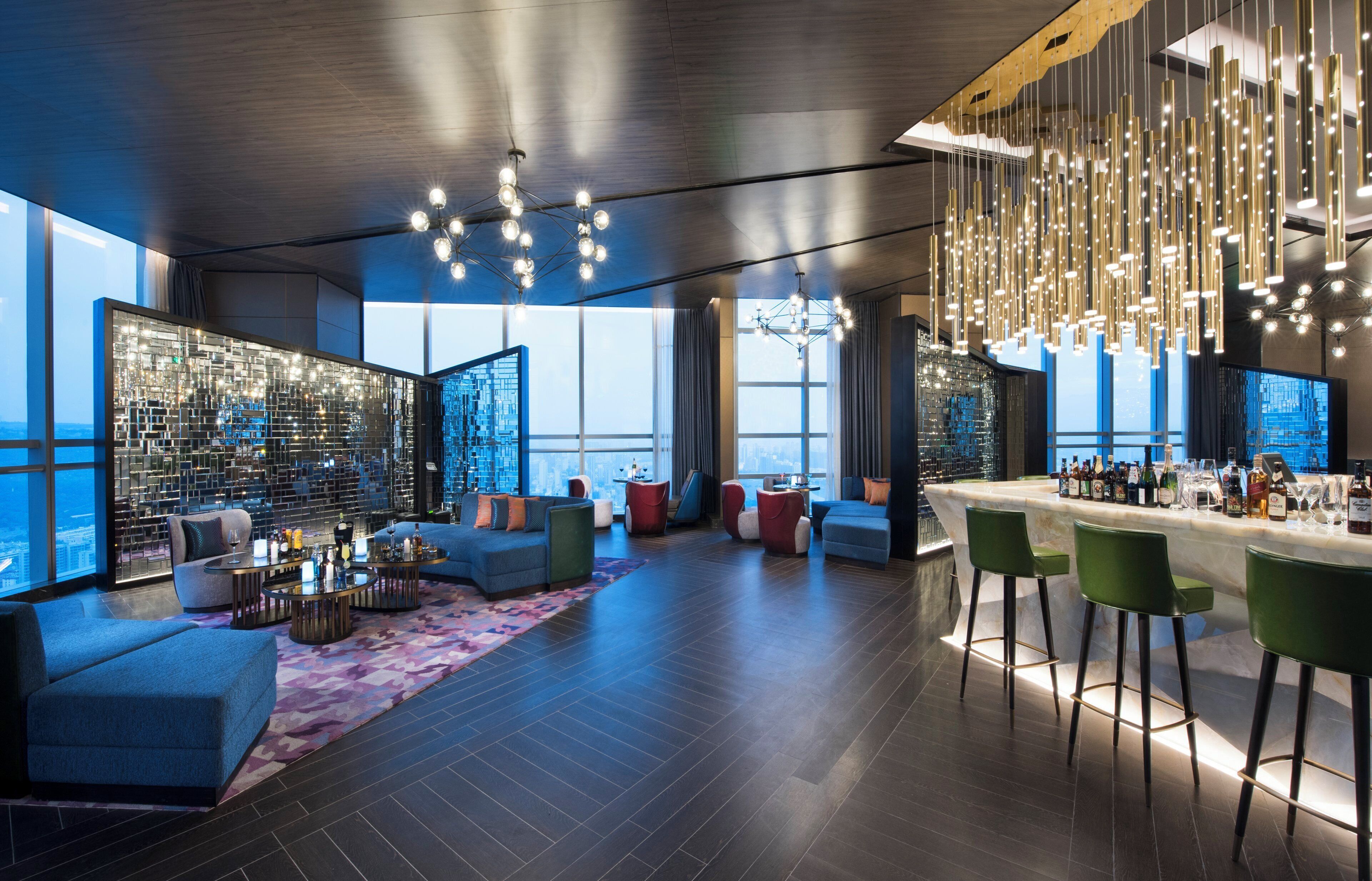 A modern interior with a bar area, seating, and large windows.