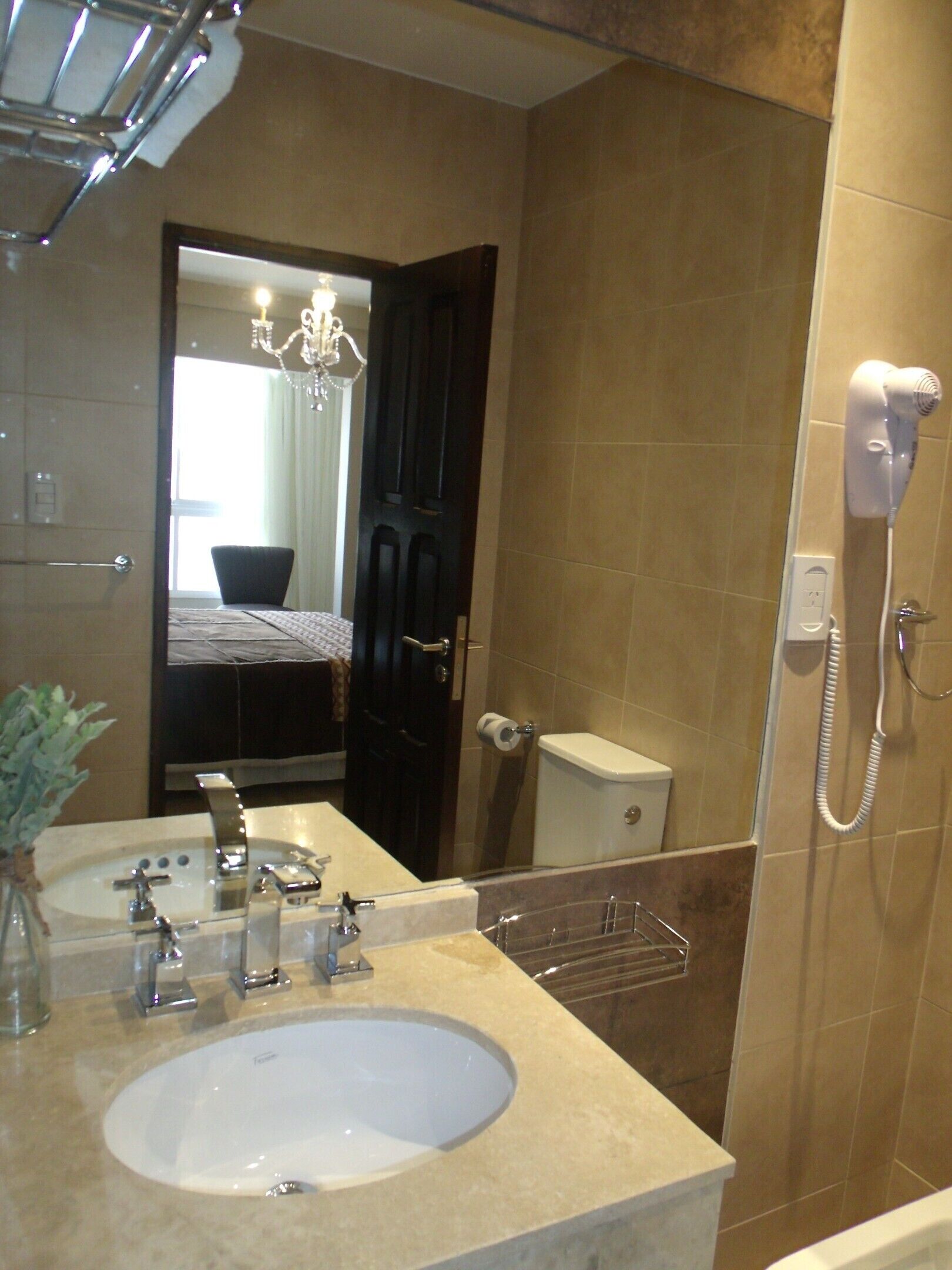 A bathroom with a sink, mirror, and a hairdryer.