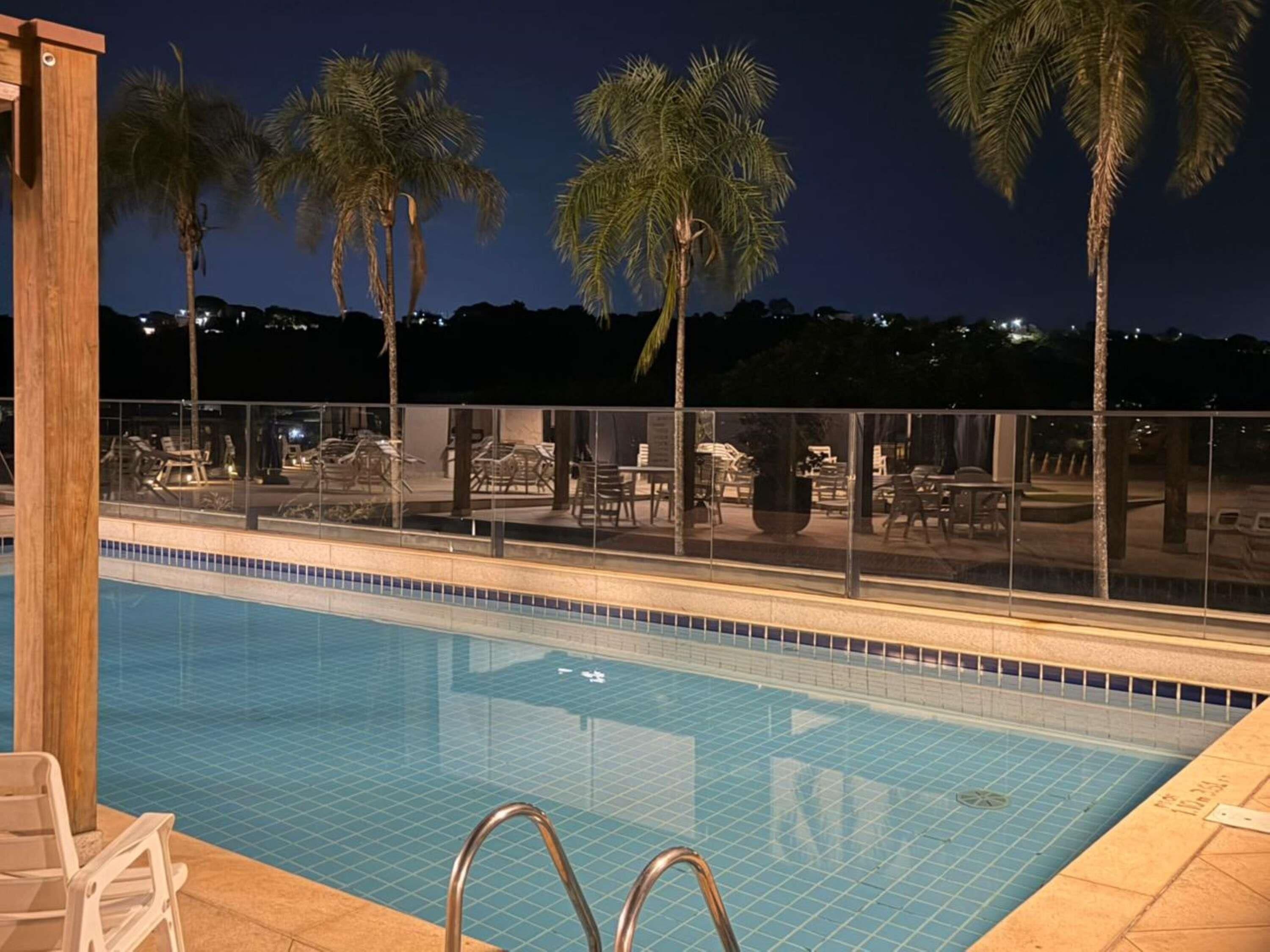 Una piscina al aire libre, sillones reclinables de piscina