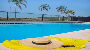 Una piscina al aire libre, sombrillas