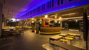 A modern interior with a reception desk, seating areas, and a patterned floor. - Ibis Styles Taubate (Taubate)