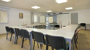 A conference room with a long table, chairs, a projector screen, and a whiteboard. - The Originals City, Hôtel la Belle Étape, Brignoles (Brignoles)
