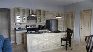 Une cuisine moderne dotée d’un îlot central, de meubles en bois et de luminaires suspendus.