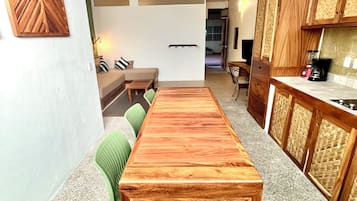Una cocina moderna con armarios de madera, una mesa de comedor y un área de estar con sofá y sillas.