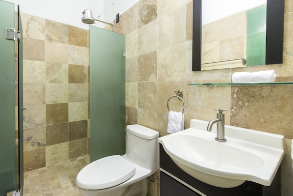A bathroom with a toilet, sink, and shower.