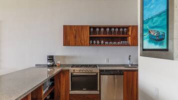 A modern kitchen with wooden cabinets, a built-in wine rack, a stove, and a dishwasher.