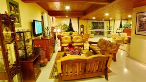 A spacious living room with leather sofas, wooden coffee table, and a television. - Hotel Sky (Gramado)