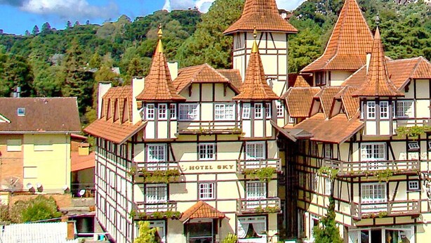 A traditional European hotel with multiple gabled roofs and a central tower. - Hotel Sky (Gramado)