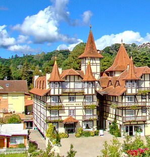 Un hotel europeo tradicional con varios tejados a dos aguas y una torre central.