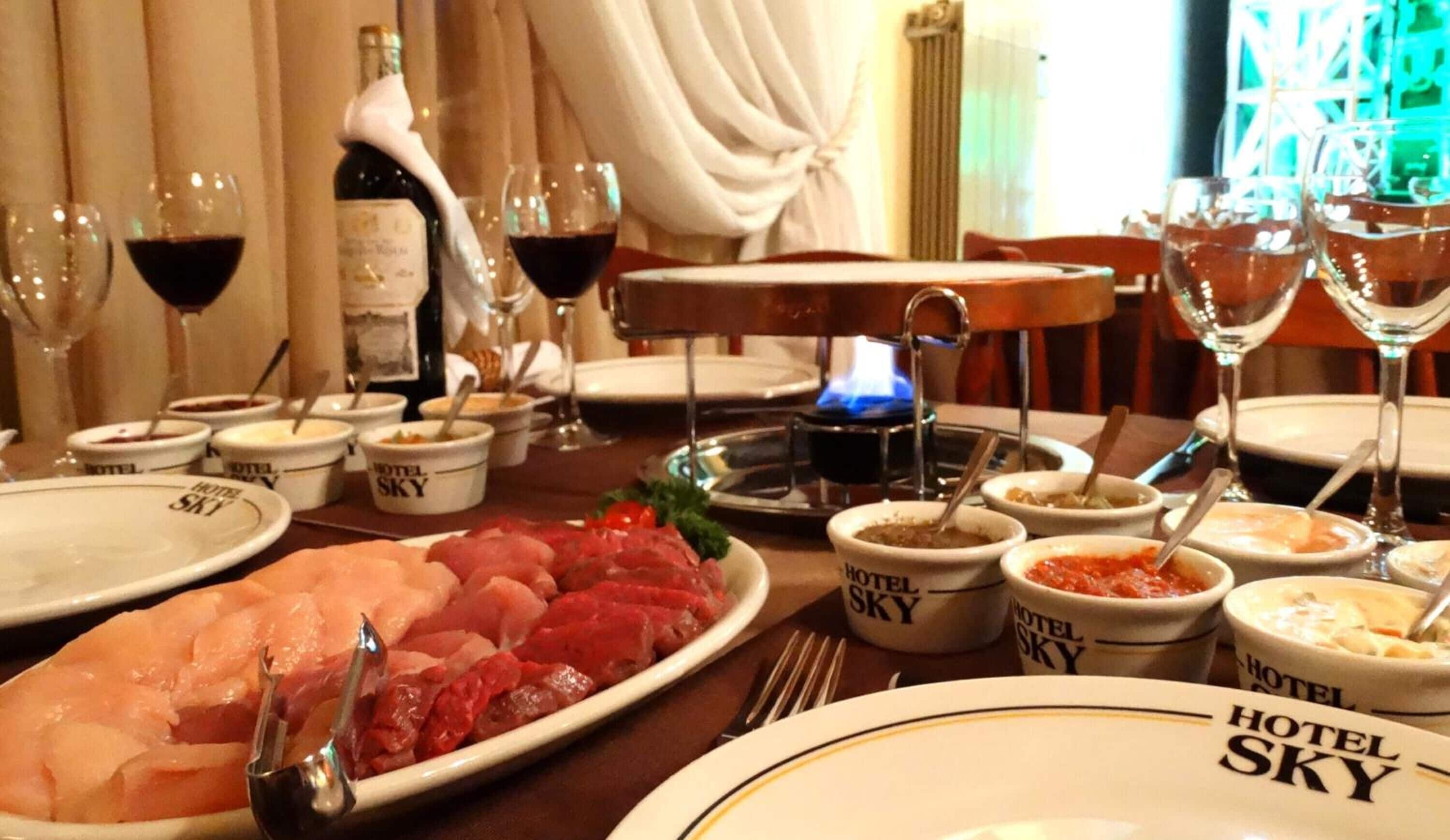 A dining table set with plates, bowls, and glasses, indicating a meal setting.