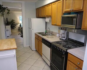 Een koelkast met diepvriezer, een microgolfoven, een oven, een kookplaat