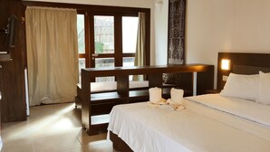A hotel room with a bed, a desk, a chair, a window with curtains, and a door. - Hotel São Francisco (Jijoca de Jericoacoara)