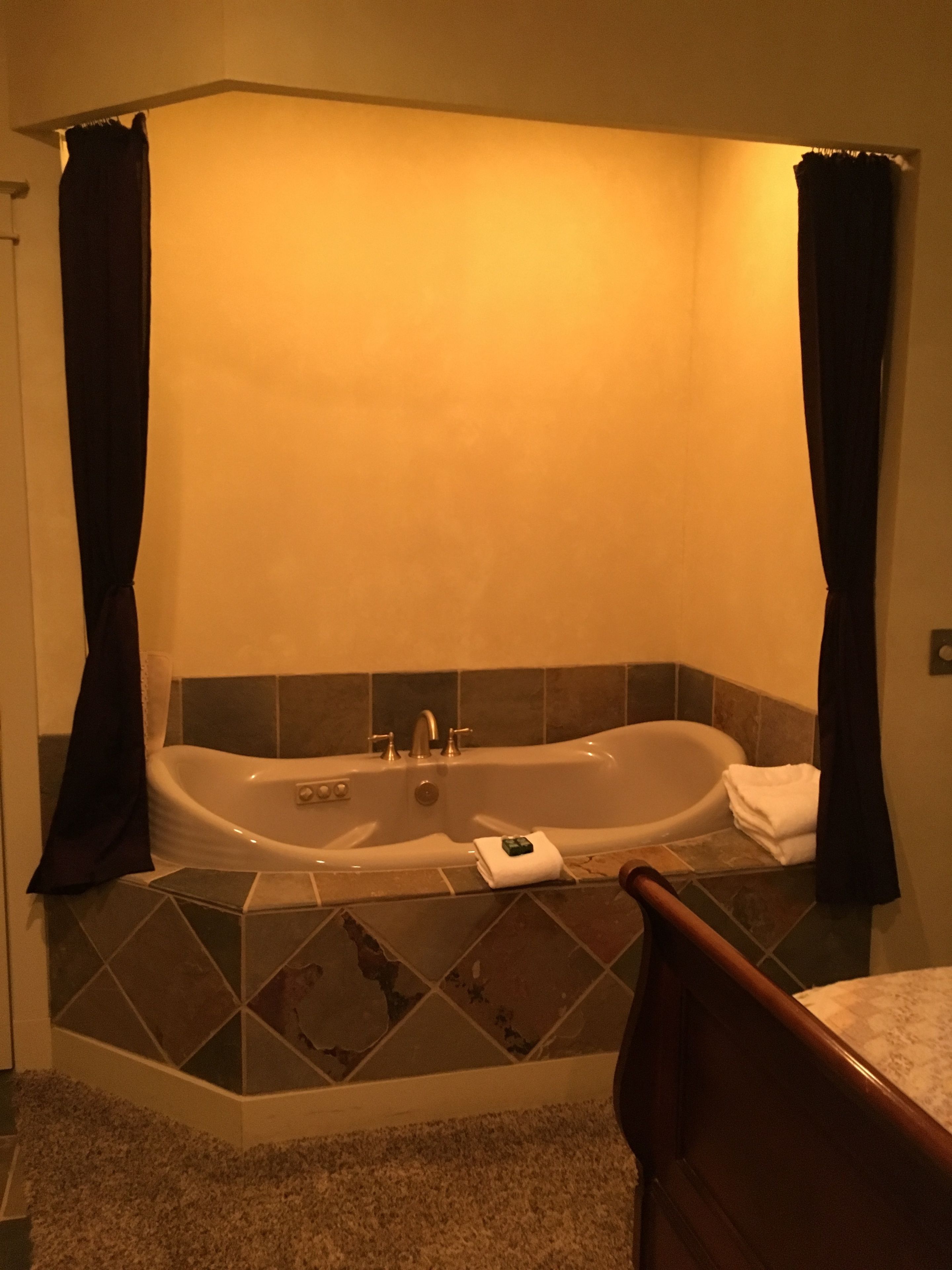 A bathroom with a freestanding bathtub, a towel rack, and a shower curtain.