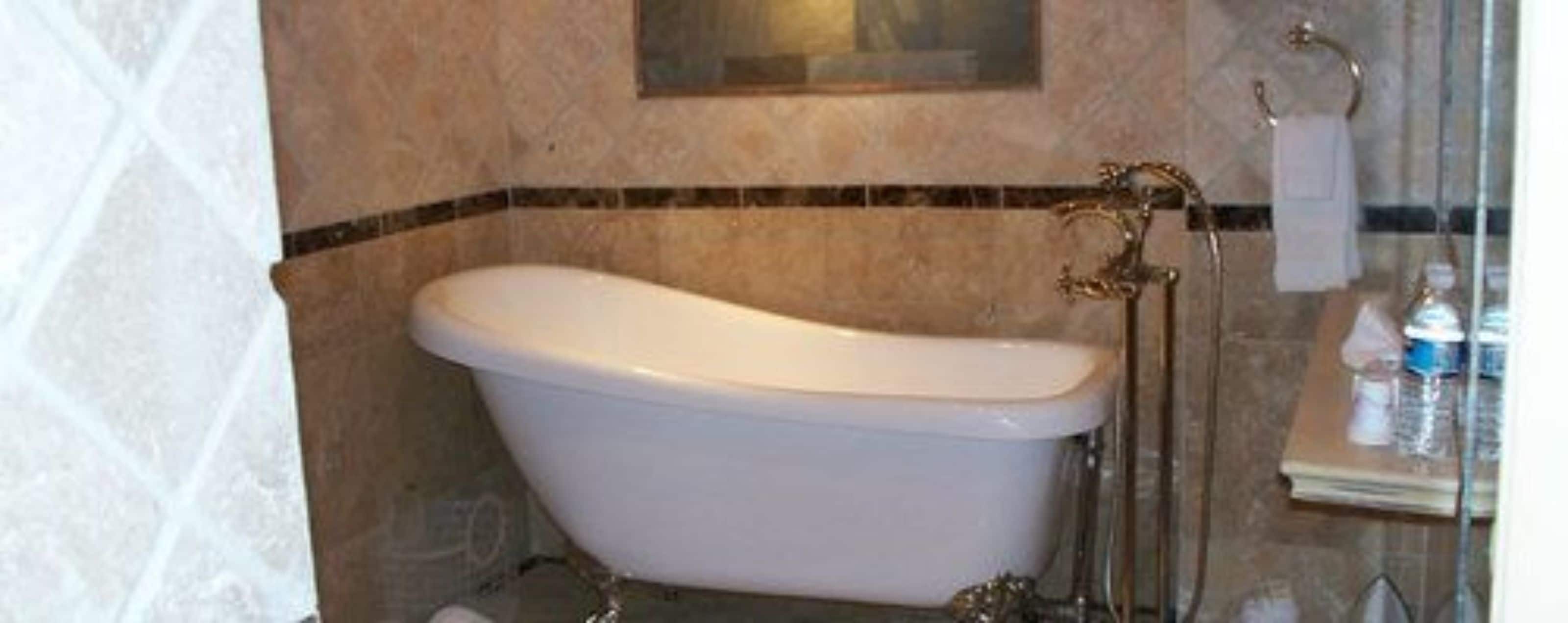 A bathroom with a freestanding bathtub, a towel rack, and a glass shower enclosure.