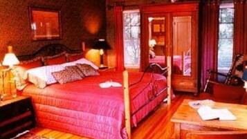 A room with a wooden bed, a desk, and a chair.