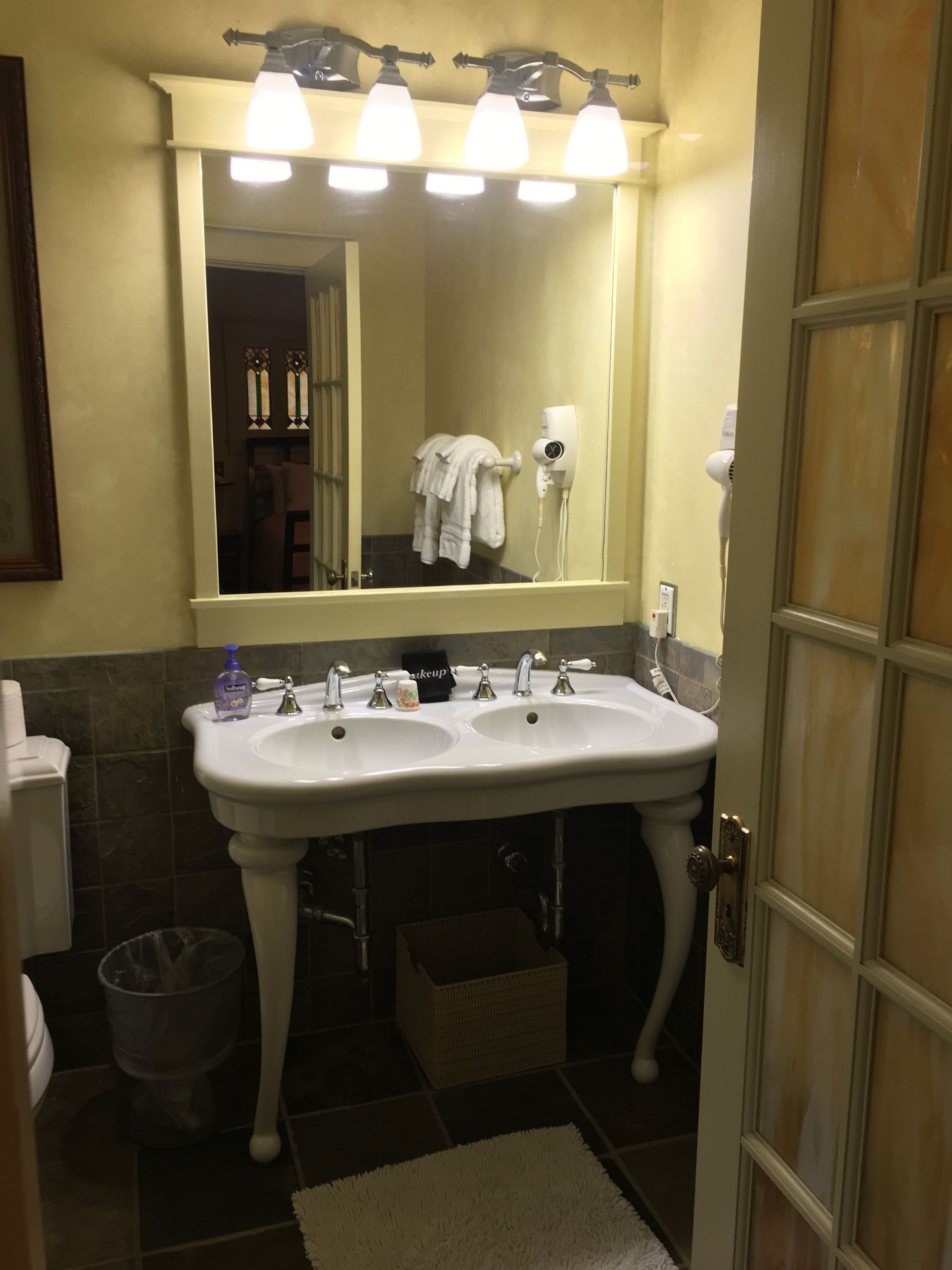 Ein Badezimmer mit zwei Waschbecken, einem Spiegel und einem Haartrockner.