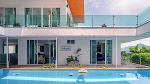 Edifici modern de dues plantes amb piscina, baranes de vidre i un rètol que indica un preu de 22,00 U.