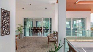A modern interior with a dining area, large windows, and a balcony. - Kamala Heights (Kamala)