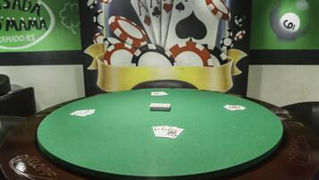 Una mesa de blackjack de fieltro verde con cuatro cartas y una ficha blanca encima.