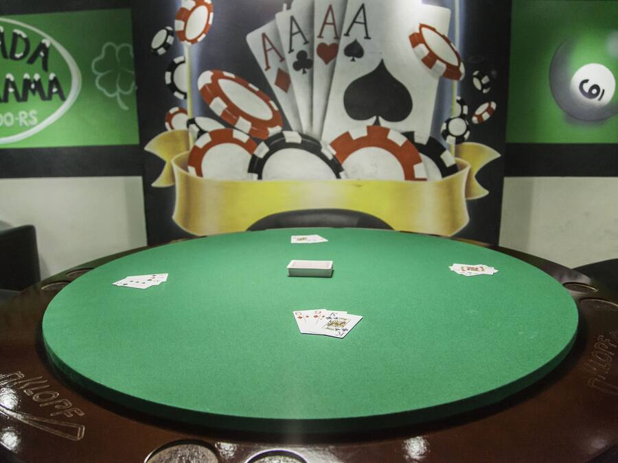 Una mesa de blackjack de fieltro verde con cuatro cartas y una ficha blanca encima.