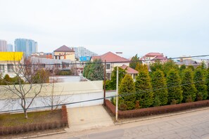 A residential area with houses, a yellow building, and a view of high-rise buildings in the background. - Arcadia Villa (Odesa)