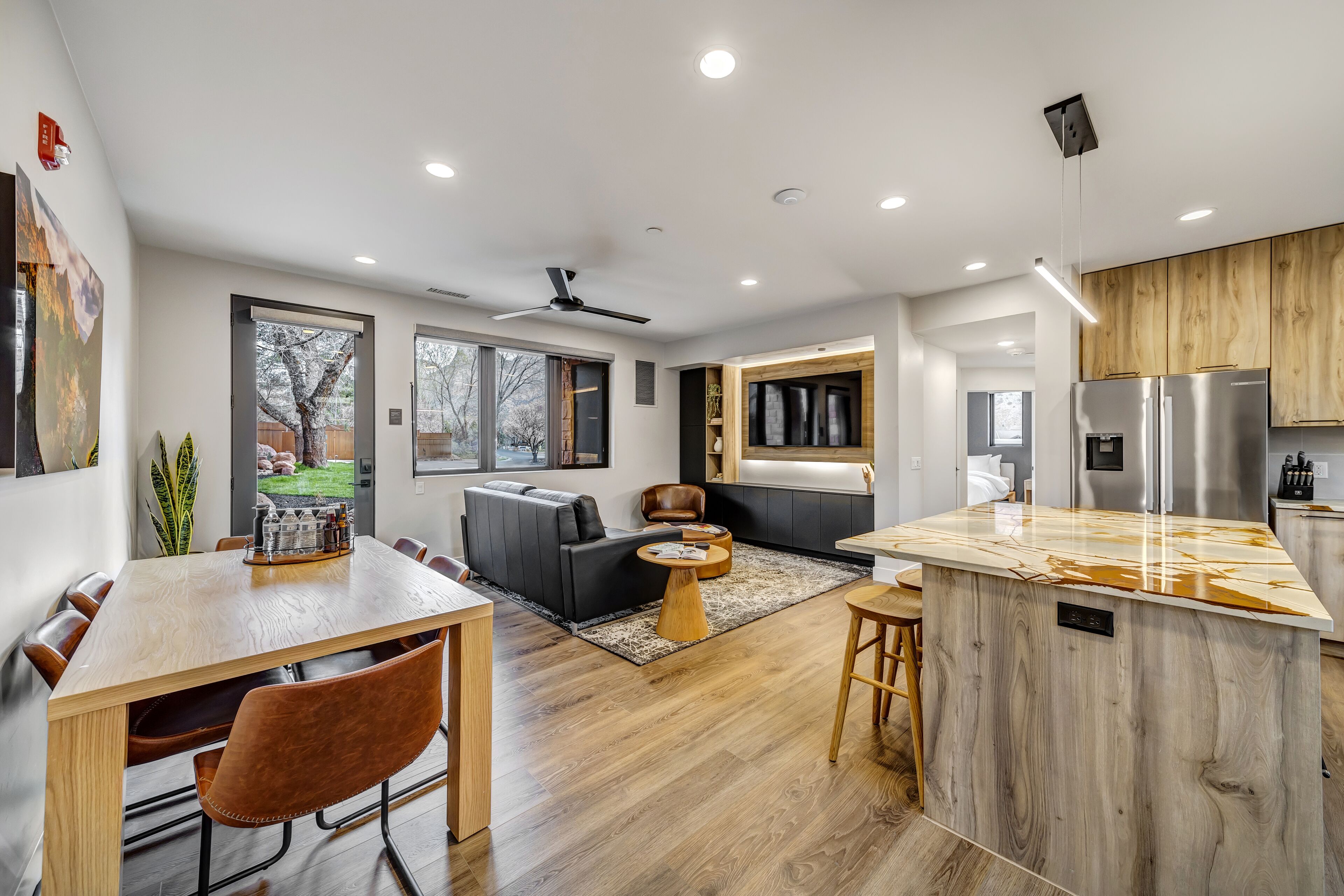Una cocina moderna con una isla central, armarios de madera y electrodomésticos de acero inoxidable.