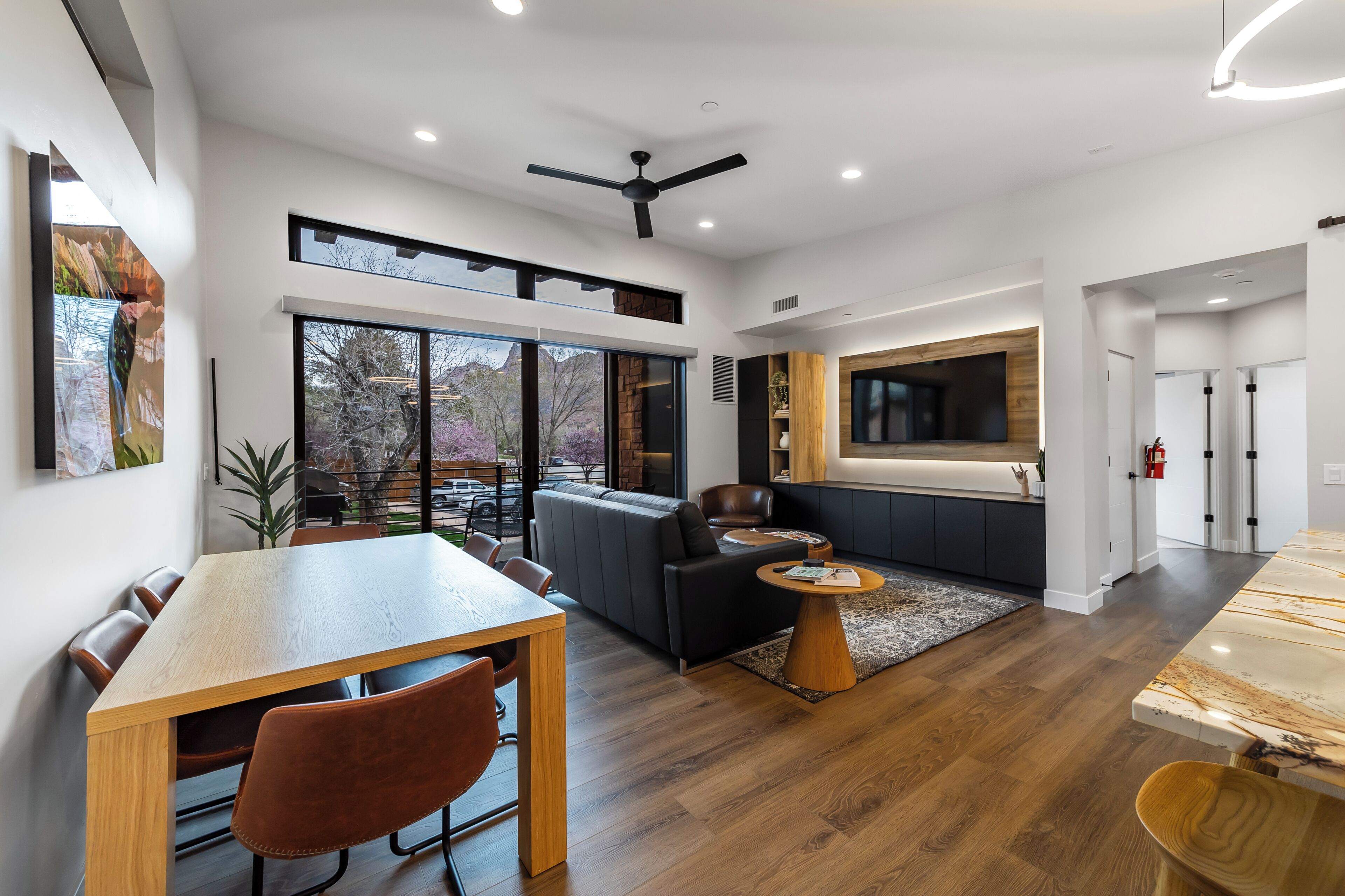 A modern interior with a dining area, sofa, and kitchen.