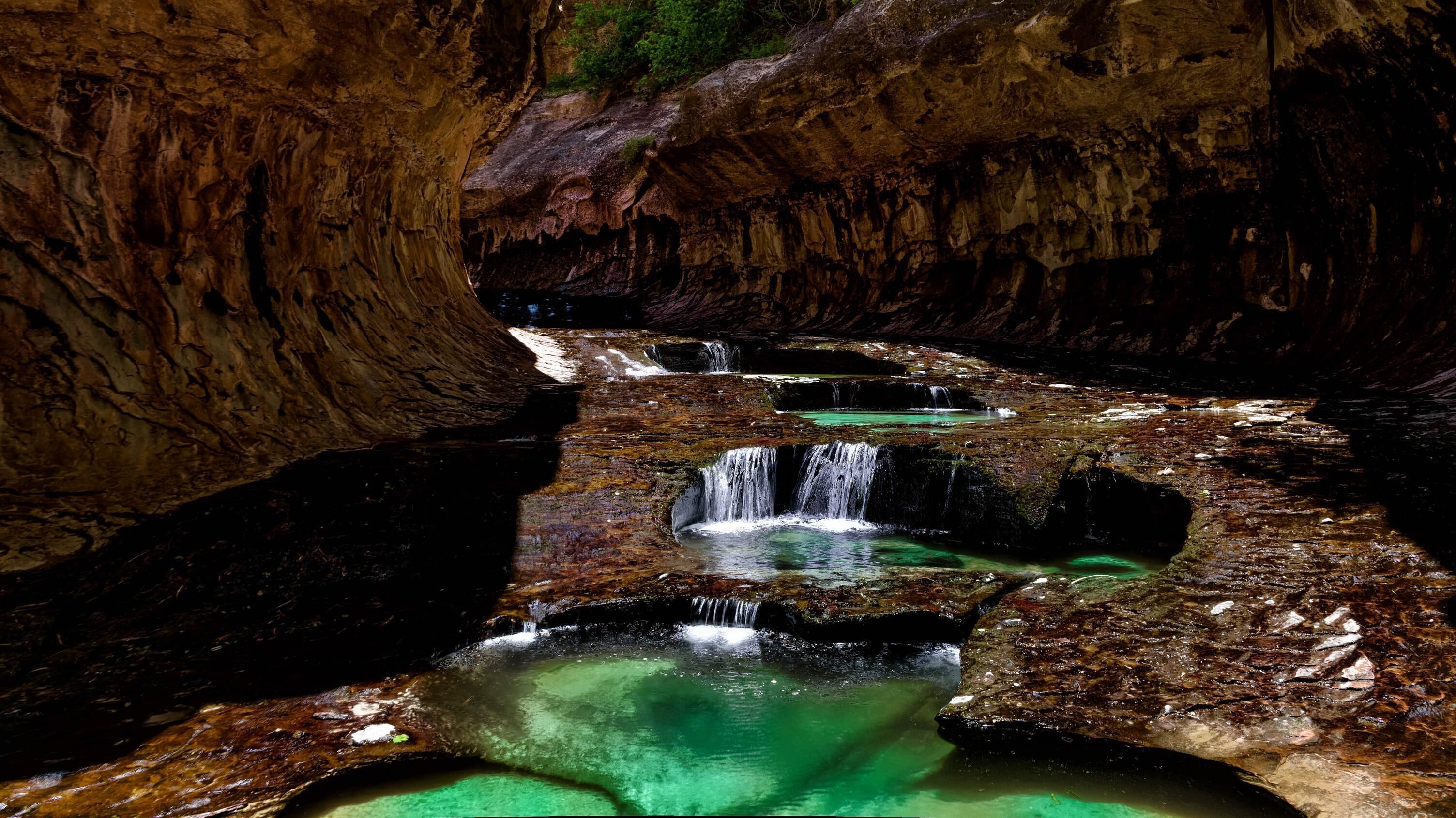 A natural rock formation with cascading waterfalls and clear pools.
