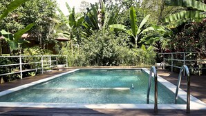 A rectangular pool with metal railings on a wooden deck, surrounded by lush tropical vegetation. - Boutique Hotel y Spa Tangara Azul (Ciudad Cortés)