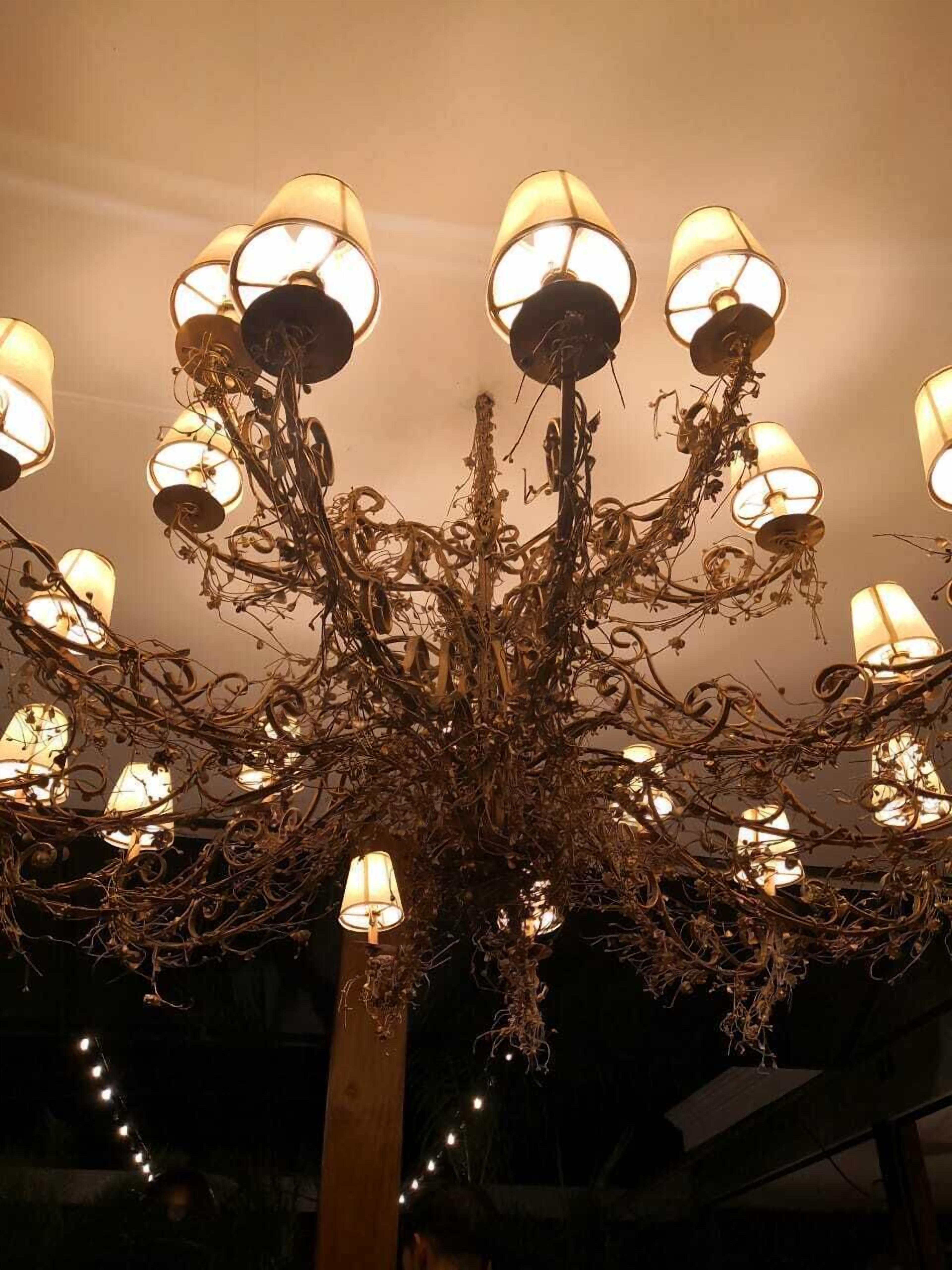 A chandelier with multiple lampshades and a central metal structure.