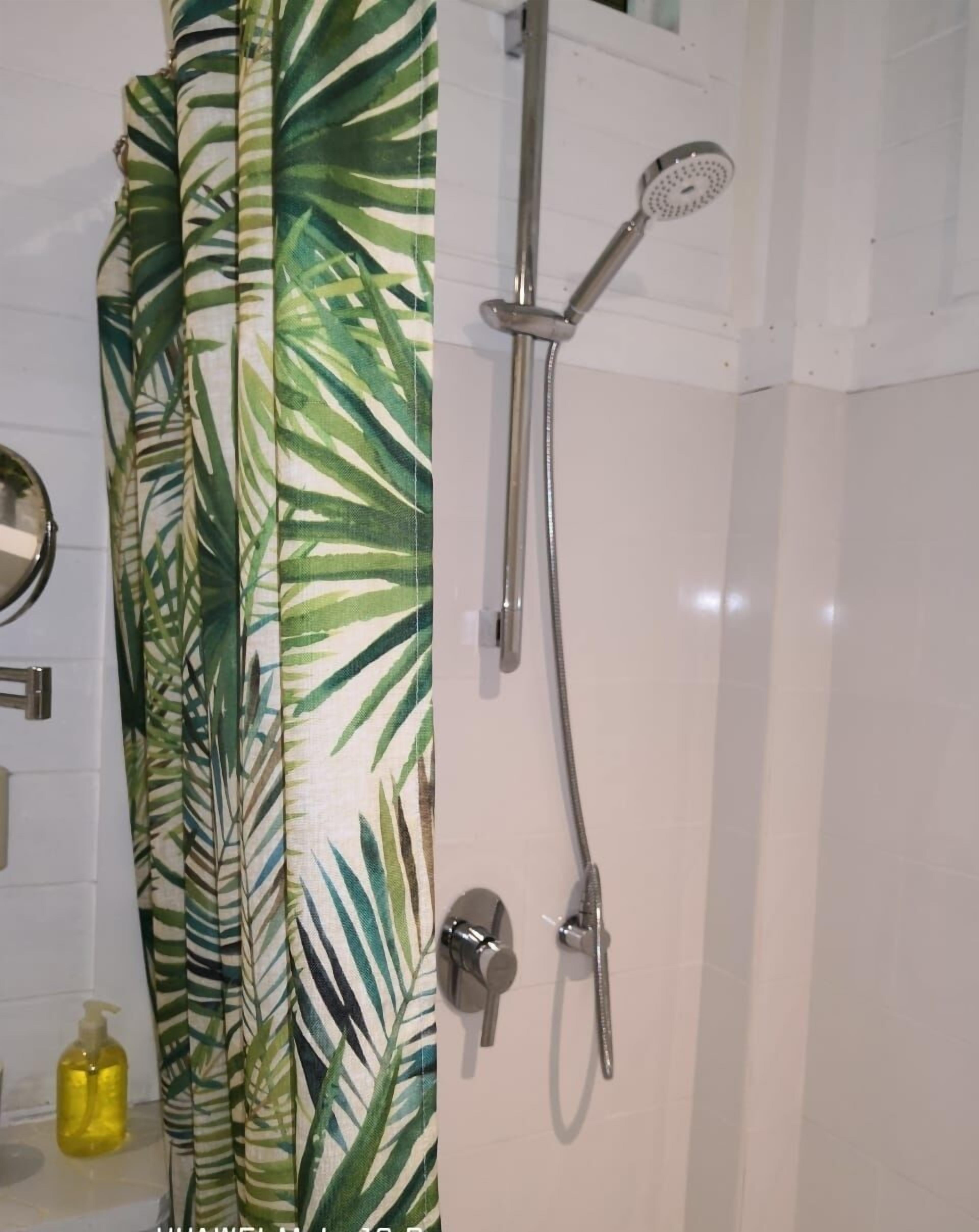 Een badkamer met een douche, toilet en wastafel.