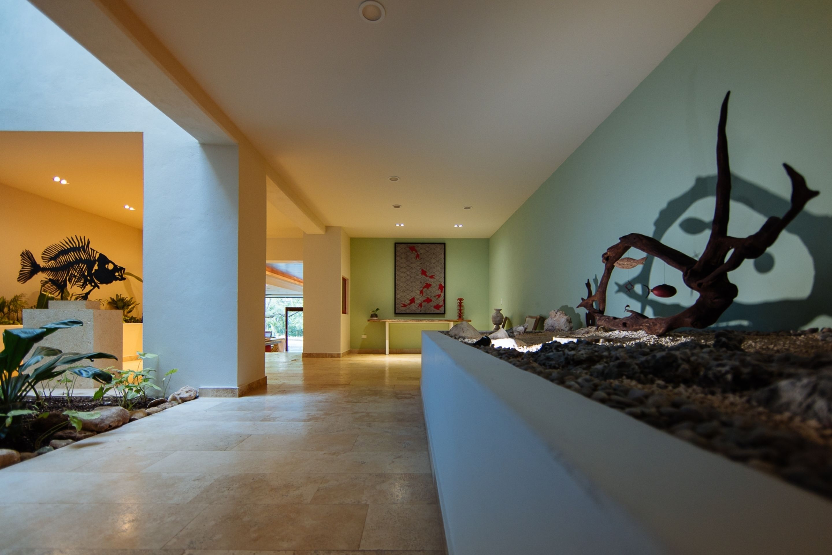 A modern lobby with a large aquarium, a fish skeleton sculpture, and a minimalist art piece on the wall.