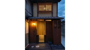 A traditional Japanese building with a wooden entrance, a sliding door, and a small potted plant. - Toji Akebono-an (Kyoto)