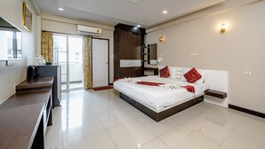 Una habitación de hotel moderna con una cama grande, un escritorio y un armario.