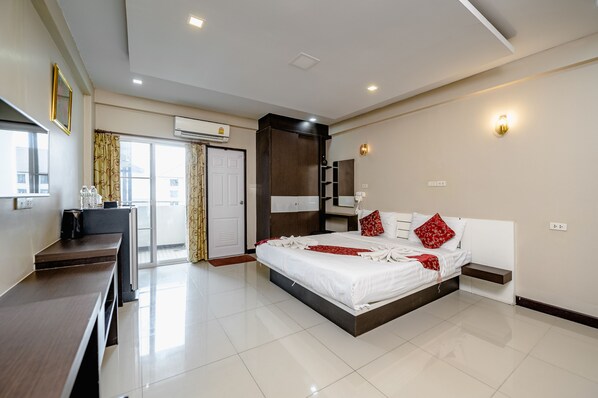 A modern hotel room with a large bed, a desk, and a wardrobe. - Gold Airport Suites (Bangkok)
